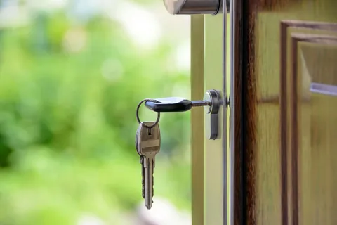 House key in a front door lock, representing buying your first Illinois home